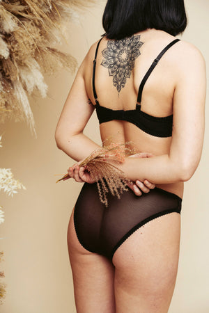 Shot from behind of a model wearing the black Kauf Bandeaux Wire Bra and High Leg Knicker