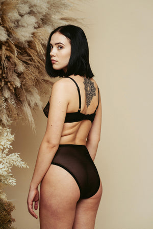 Model seen from the back, wearing the Kauf High Waisted Knicker and Bandeaux Wire Bra in black